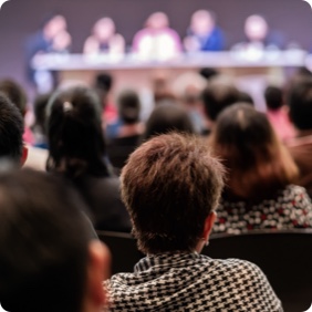 Crowd of people watching a panel discussion