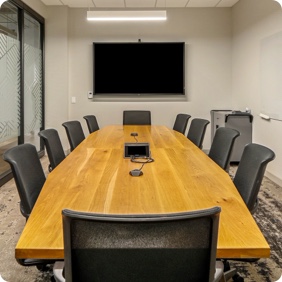 office space with large desk and screen for presentations